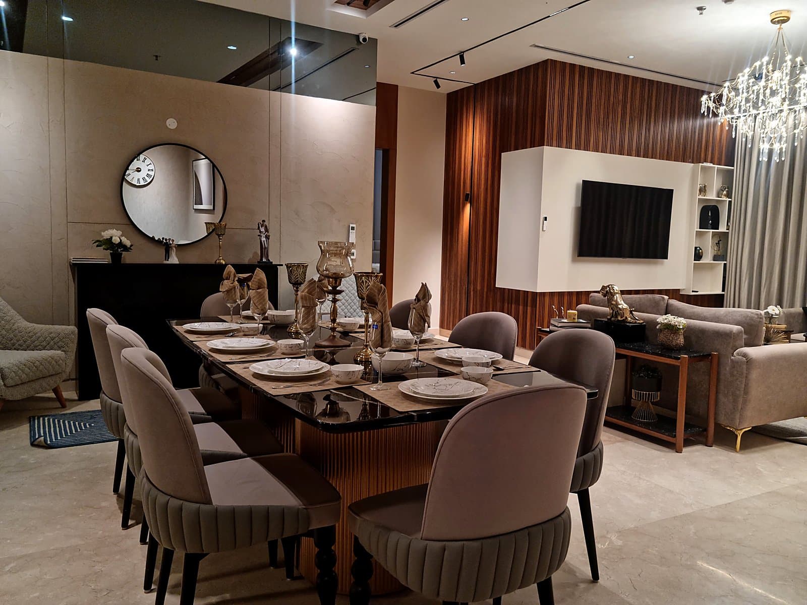 Formal 8-seater dining area with wall clock and mirror accent in premium Mohali flat