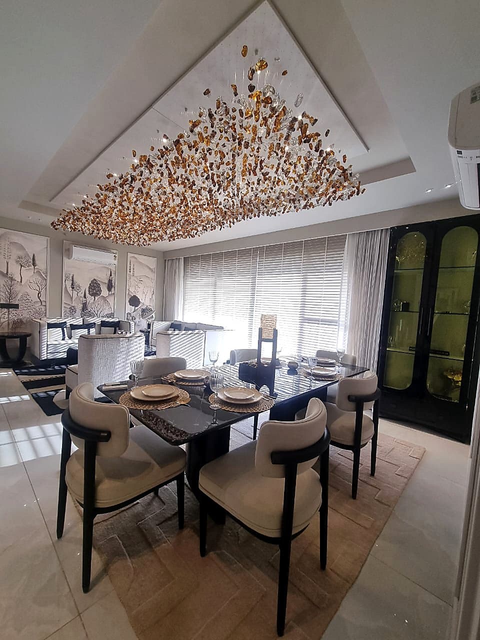 Formal dining area with crystal chandelier and crockery cabinet in Zirakpur property
