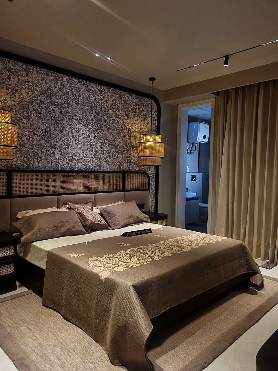 Guest bedroom with cane headboard and pendant lights in luxury Zirakpur flat