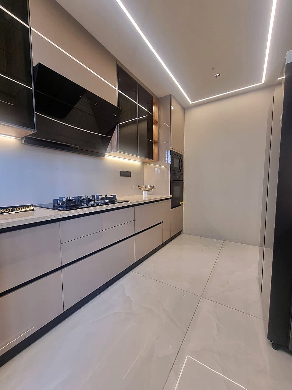 Modern modular kitchen with LED strip lighting and built-in appliances in Zirakpur flat
