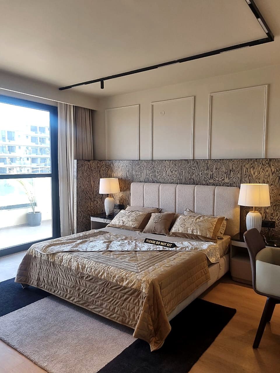 Master bedroom with designer headboard and balcony view in IGBC Platinum Zirakpur flat