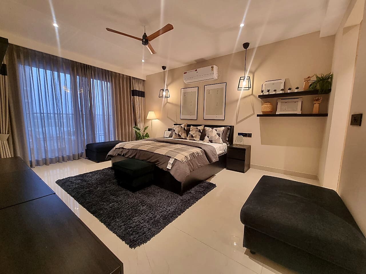 Bedroom with pendant lights, geometric cushions, and floating shelves in smart home Zirakpur property
