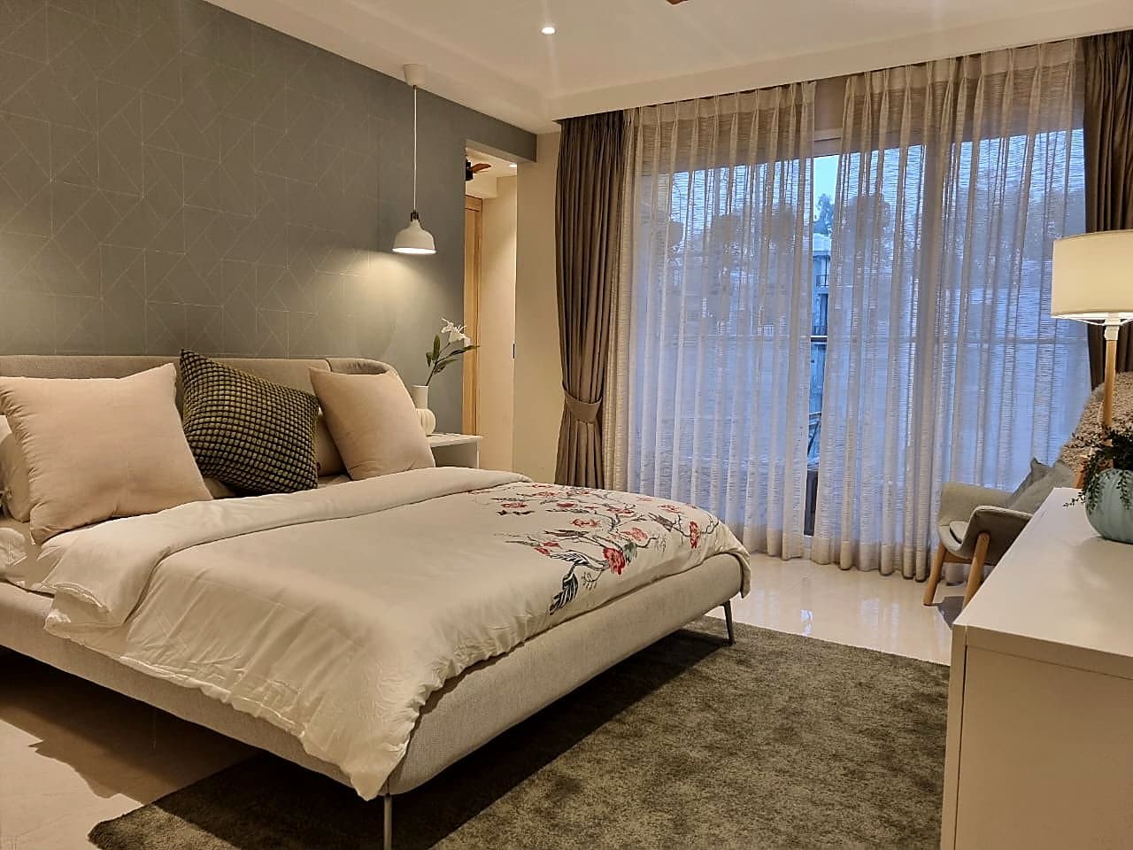 Master bedroom with grey geometric accent wall and sheer curtains in ultra luxury Zirakpur flat