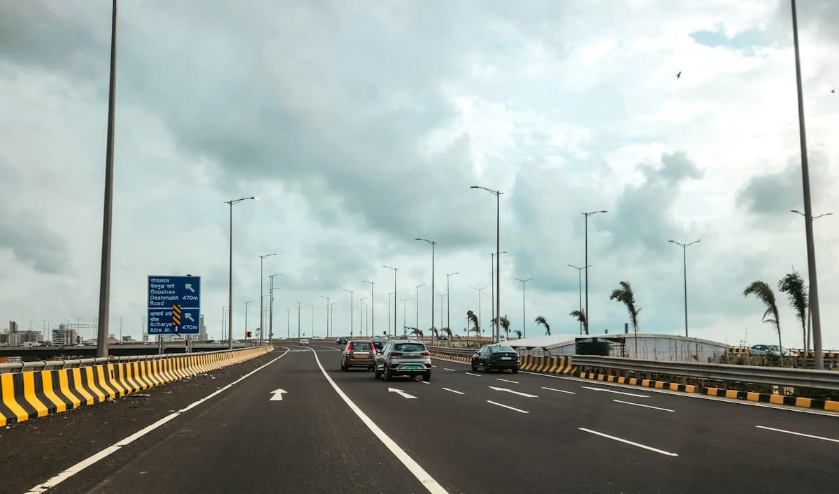 Indian coastal expressway with cars and Hindi road signage showing infrastructure growth